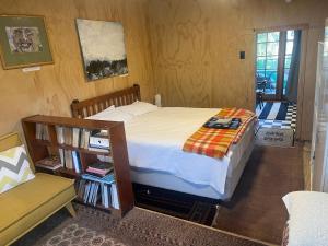 a bedroom with a bed and a book shelf at The Windsor Suite in New Plymouth
