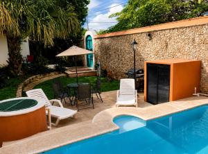 a patio with a pool and chairs and a table at Villa Odalys Cozy Mexican style house in Mérida