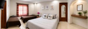 a bedroom with a bed and a chair and a window at Villa Odalys Cozy Mexican style house in Mérida