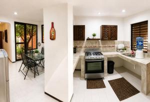 a kitchen with a stove and a dining room at Villa Odalys Cozy Mexican style house in Mérida