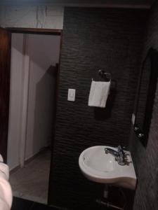 a bathroom with a sink and a black wall at Apartaestudio in Chiquinquirá