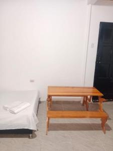 a room with a wooden table next to a bed at Apartaestudio in Chiquinquirá