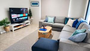 a living room with a couch and a tv at Busselton Beach Villa - Family & Pet Friendly in Geographe