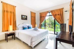 a bedroom with a bed and a large window at Baan Klong Resort in Damnoen Saduak