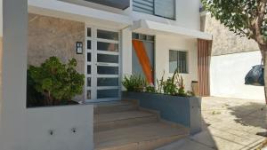 a house with stairs and plants in front of it at Hospedaje Smart Wasi Sucre in Sucre