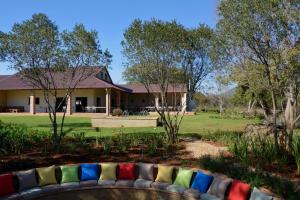 a garden with a couch in front of a house at Esther's Country Lodge in Hekpoort