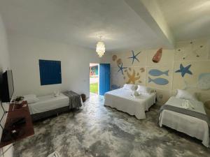 a room with two beds and a tv in it at Pousada Villa Japa in Maragogi +20 photos