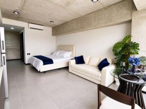 a bedroom with a bed and a couch and a table at Estudio 905 in San Salvador +11 photos