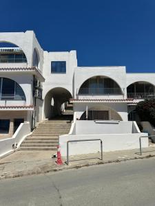 a white building with stairs and a red fire hydrant at Beachfront Bliss in Pissouri