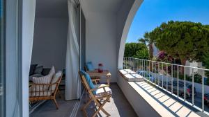 a balcony with chairs and a table and a tree at Beachfront Bliss in Pissouri