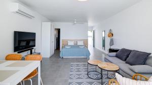 a living room with a couch and a tv at Beachfront Bliss in Pissouri
