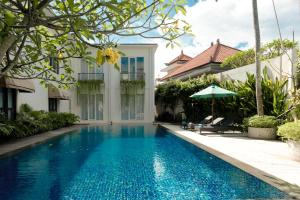 a swimming pool in front of a house at Umpadhi Canggu in Canggu