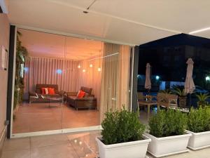 a living room with glass doors and plants in pots at Hotel Futuro in Aversa