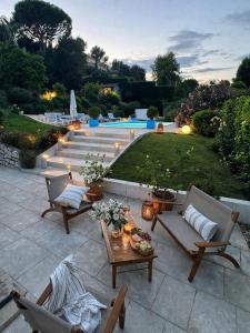 a patio with chairs and a table and a pool at Villa Del Sol with Mountain Views in Vence