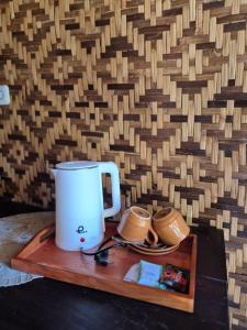 a coffee maker on a wooden tray next to a wall at Tebu menjangan homestay in Banyuwedang