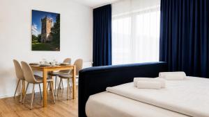 a bedroom with a bed and a table with chairs at KOMM - Panoramablick - Balkon - Küche - Parkplatz in Suhl
