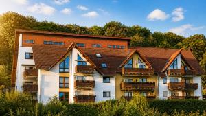 an apartment building with a brown roof at KOMM - Panoramablick - Balkon - Küche - Parkplatz in Suhl