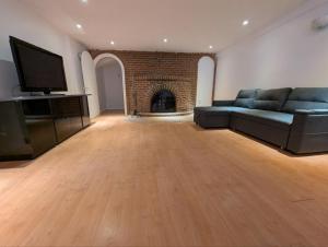 a large living room with a couch and a television at Home rental S7 in Saint Maurice