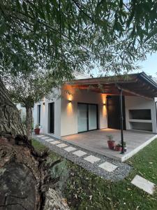 a white house with a tree in front of it at La Elenita Tandil in Tandil