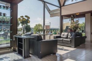 a living room with leather furniture and glass windows at Rodeway Inn Fallsview in Niagara Falls