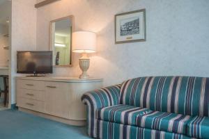 a living room with a couch and a television at Rodeway Inn Fallsview in Niagara Falls