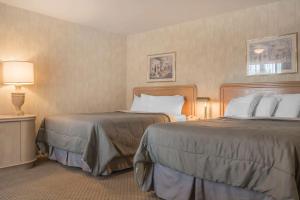 a hotel room with two beds next to each other at Rodeway Inn Fallsview in Niagara Falls +22 photos