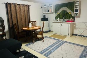 a room with a table and a kitchen with a table and chairs at Manutapu Lodge in Tongatapu