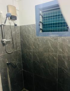 a shower in a bathroom with a window at Manutapu Lodge in Tongatapu