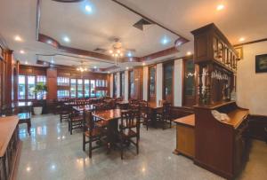 a dining room with tables and chairs in a restaurant at Khampiane Hotel in Vientiane