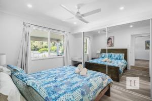 a bedroom with two beds and a window at Sunset Escape in Summerland Point