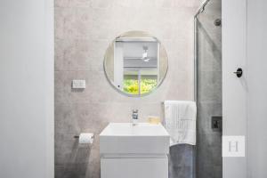 a bathroom with a sink and a mirror at Sunset Escape in Summerland Point +25 photos