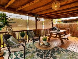 a patio with chairs and a table on a deck at Pipeline Tropical Bungalow in Haleiwa