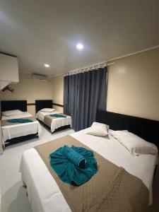 a bedroom with two beds with blue sheets at Visk Palace Hotel e Restaurante in Foz do Iguaçu +21 photos