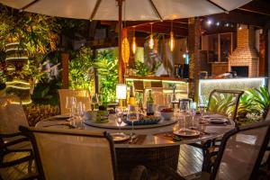 a table in a restaurant with an umbrella at Búzios House Oficial in Búzios