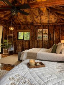 a bedroom with two beds in a room with wooden walls at Pipeline Tropical Bungalow in Haleiwa