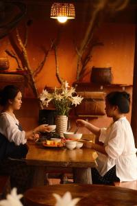 two women sitting at a table eating food at La Beauté Nghia Do in Nghĩa Ðô +39 photos