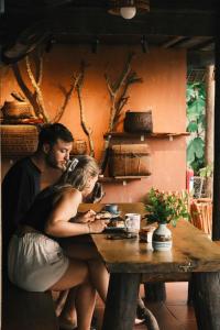 a man and a woman sitting at a wooden table at La Beauté Nghia Do in Nghĩa Ðô