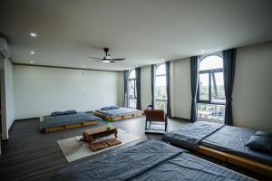 a bedroom with three beds and a table in it at Khách Sạn Vân Nguyên in Buôn Ea Yông