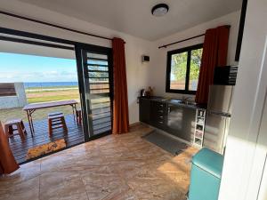 a kitchen with a table and a view of the ocean at Pautoora Lodge in Rurutu