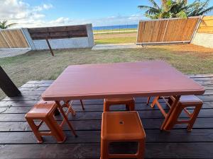 a picnic table and a bench on a deck at Pautoora Lodge in Rurutu