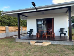 a house with a deck with chairs and a table at Pautoora Lodge in Rurutu