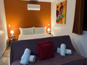 a bedroom with a bed and a couch with pillows at Pautoora Lodge in Rurutu