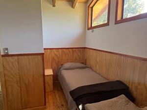 a small room with a bed and a window at Colibrí lodge in Recinto