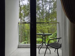 Ein Tisch und Stühle vor einem Fenster in der Unterkunft BBIB Suites in Wonorejo