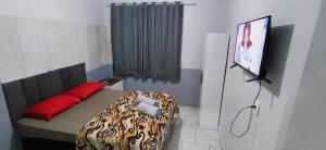 a room with a bed and a television in it at Pousada Familiar 01 in Rio do Sul