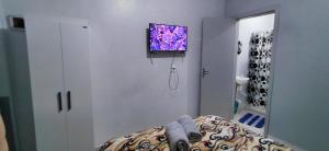 a room with a tv hanging on the wall at Pousada Familiar 01 in Rio do Sul
