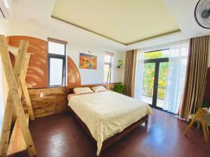 a bedroom with a large bed and a large window at Laoxao Homestay in Hoi An