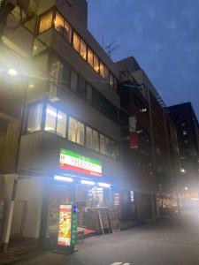 a store with a sign in front of a building at unito light SHIMBASHI in Tokyo
