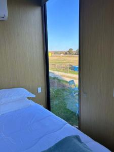 a bedroom with a bed and a view of a field at Ritaville by Tiny Away in Eaton