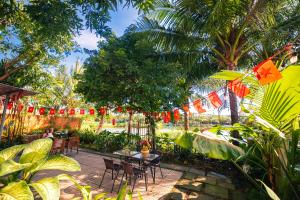 a patio with a table and chairs and flags at Laoxao Homestay in Hoi An
